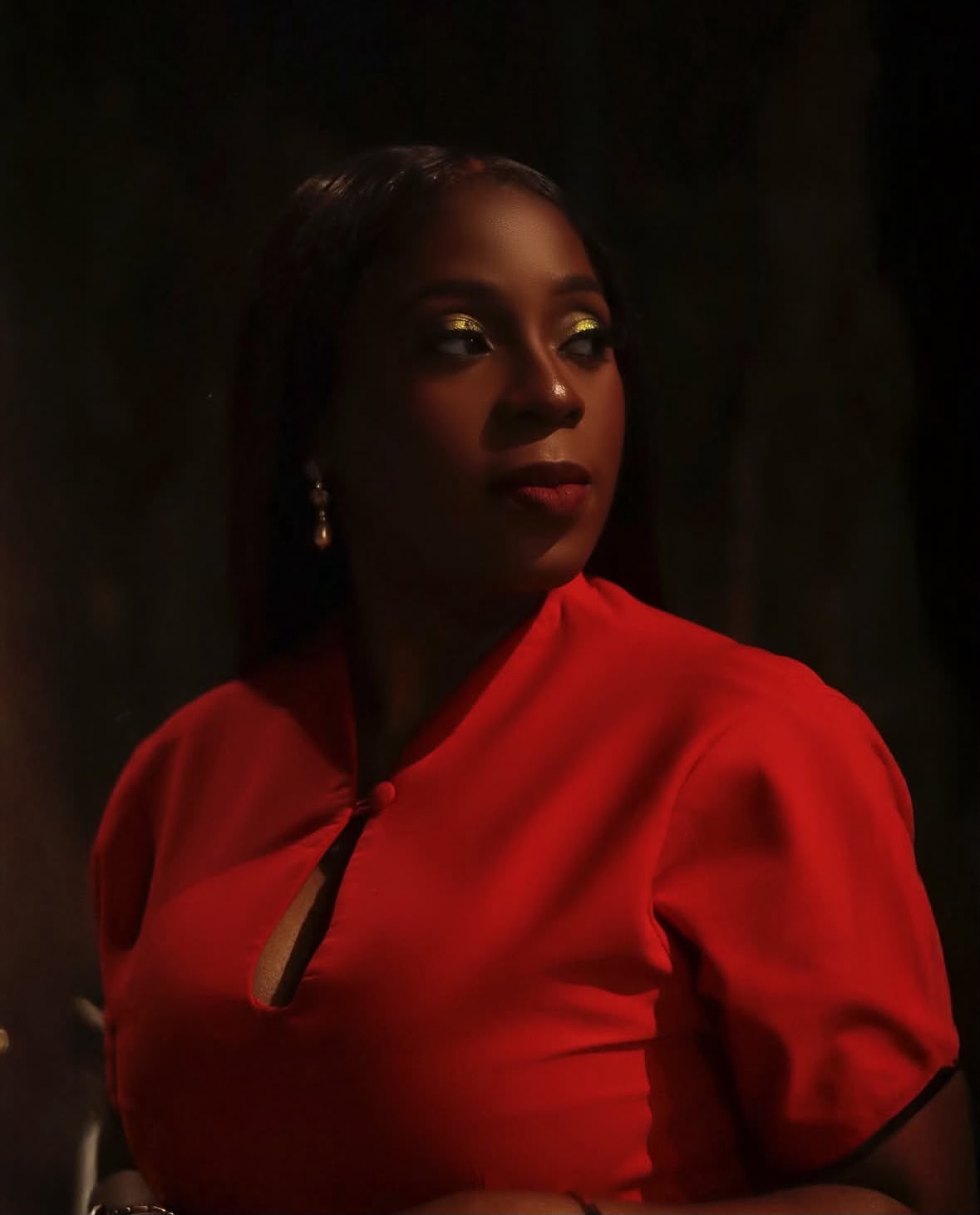 Damilola Awokola, Creative Director of The House of Dee, in a red dress with gold eye makeup